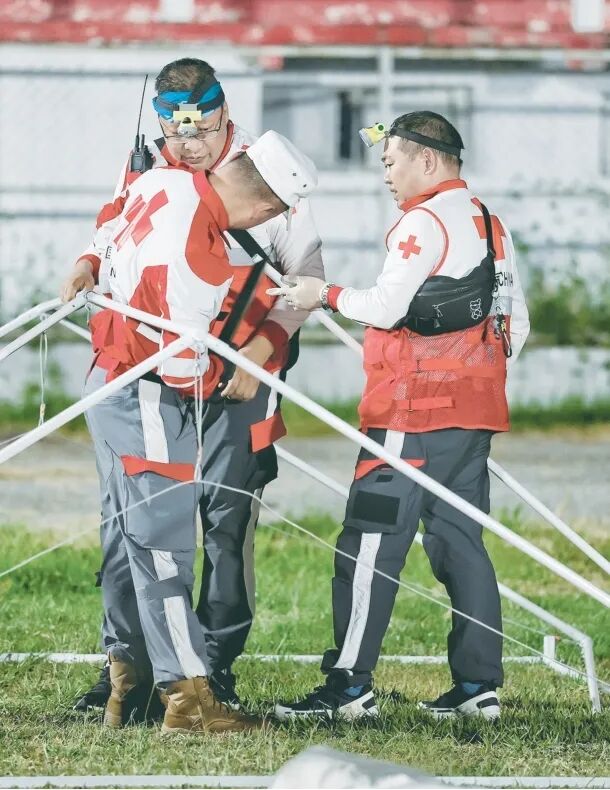 2025年4月6日,楚雄州红十字会救援队员在缅甸曼德勒地震灾区搭建受灾群众安置点。 图片